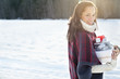 Portrait of smiling woman carrying Christmas gifts in snow