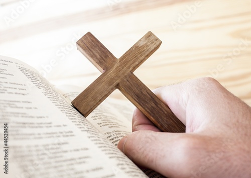 Photo: man holding the cross with bible man holding the cross with bible