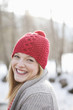 Close up portrait of smiling woman with red knit hat