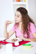 .Young woman eating yogurt