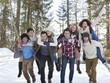 Enthusiastic couples piggybacking in snowy woods