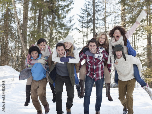 Photo: Enthusiastic couples piggybacking in snowy woods Enthusiastic couples piggybacking in snowy woods