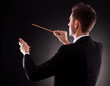 Back view of a young composer directing with his baton