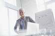 Photo: Portrait of smiling businesswoman next to graph in conference room Portrait of smiling businesswoman next to graph in conference room