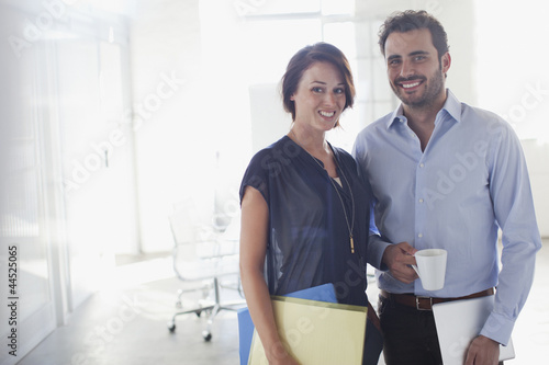 Photo: Portrait of smiling businessman and businesswoman in conference room Portrait of smiling businessman and businesswoman in conference room