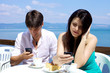 Couple texting having breakfast in front of lake