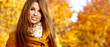 Beautiful elegant woman standing in a park in autumn