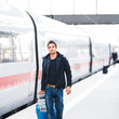 Just arrived: handsome young man walking along a platform