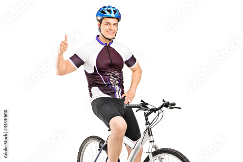 Photo: A smiling bicyclist posing on a bicycle and giving a thumb up A smiling bicyclist posing on a bicycle and giving a thumb up