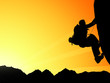 Silhouette of climbing young adult at the top of summit
