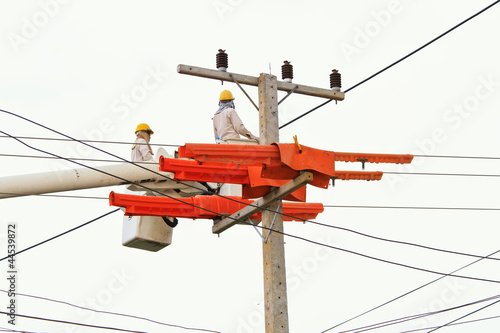 Photo: An electrical power utility worker in a bucket fixes the power l An electrical power utility worker in a bucket fixes the power l