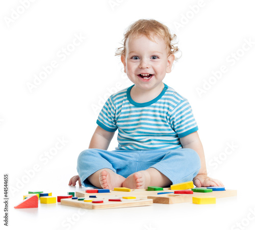 Photo: happy child playing educational toys isolated on white happy child playing educational toys isolated on white