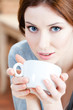 Blue-eyed woman with cup of tea has a rest at the restaurant