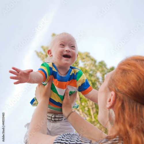 Photo: baby with Down syndrome is happy and flying up baby with Down syndrome is happy and flying up