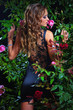 an attractive woman standing among the rose bushes