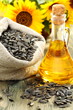 Sunflower seeds in bag and bottle of oil.