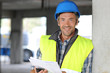 Smiling construction manager standing on building site