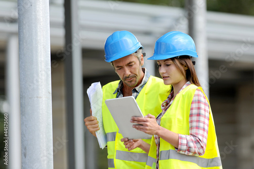 Photo: Construction people using electronic tablet on site Construction people using electronic tablet on site