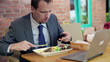 Businessman eating lunch in cafe, outdoor