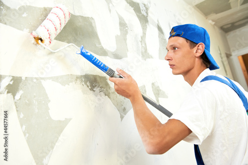 Photo: painter at home renovation work with prime painter at home renovation work with prime