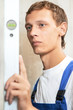 Young carpenter man worker with level