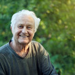 Portrait of a positive elderly man in a garden.