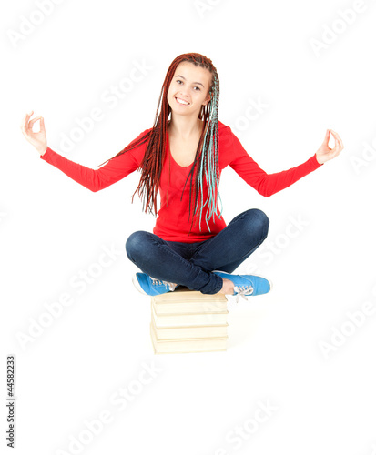 Photo: meditating young student girl with african hairdo and books meditating young student girl with african hairdo and books