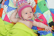 Baby with colorful hat and quilt