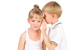 5-7 years old boy tells a secret to the girl isolated over white