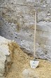 old shovel with gravel and concrete wall