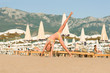 Happy girl jump and somersault on the beach Montenegro