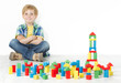 Photo: Boy sitting next to construction blocks and smiling Boy sitting next to construction blocks and smiling
