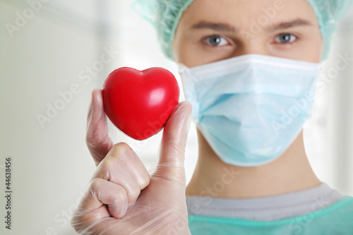 Photo: Male surgeon holding red heart Male surgeon holding red heart