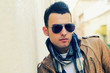 Attractive man wearing tinted sunglasses in urban background