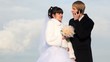 Newly-married couple stands and man talks by cellular telephone