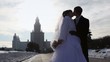 girl and man in wedding dresses kiss on area