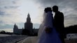 Newly-married couple stands on avenue in winter