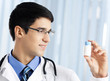 Happy doctor showing bottle of drugs
