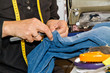 Schneiderin beim Ausbessern einer Jeanshose