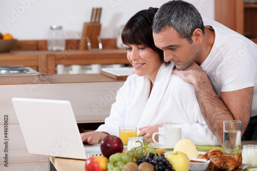 Foto: Couple eating breakfast together whilst browsing the internet Couple eating breakfast together whilst browsing the internet