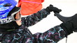 little boy holds some handle and rides on skis