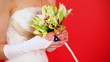 bride in white dress holding bouquet of lilies