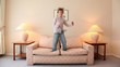 boy jumps on sofa at room with lamps on each side