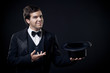 Foto: magician showing tricks with top hat isolated on dark background magician showing tricks with top hat isolated on dark background