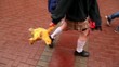 Girl walks by pavement with bloody legs and carries soft toy