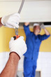 Electricians working on ceiling lighting