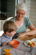 Foto: Old lady and grandson eating breakfast together Old lady and grandson eating breakfast together