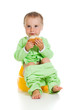 Cute baby eats the bread sitting on the pot