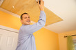 Handyman sanding ceiling