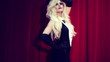 Gorgeous woman posing by the red curtains, steadicam shot